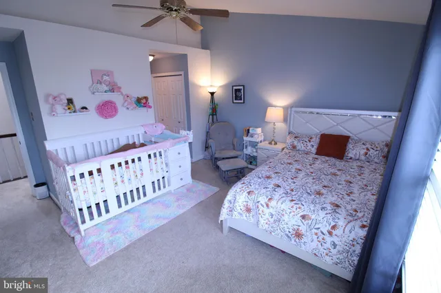 a bedroom with bed and a baby crib
