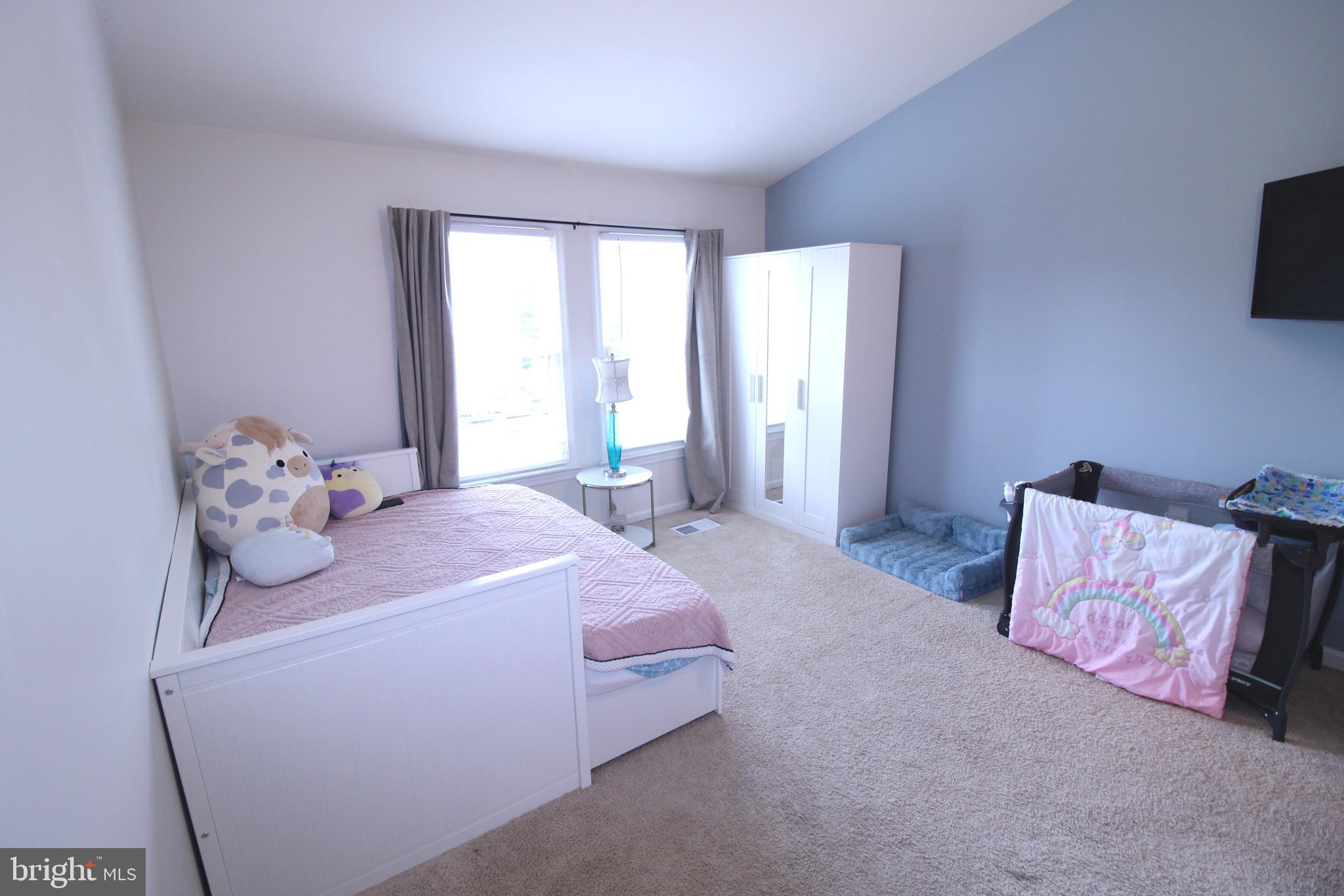 7863 Apache Ridge Court Manassas, VA 20109 - Photo 21 of 38 a bedroom with a bed and flat tv screen on the dresser
