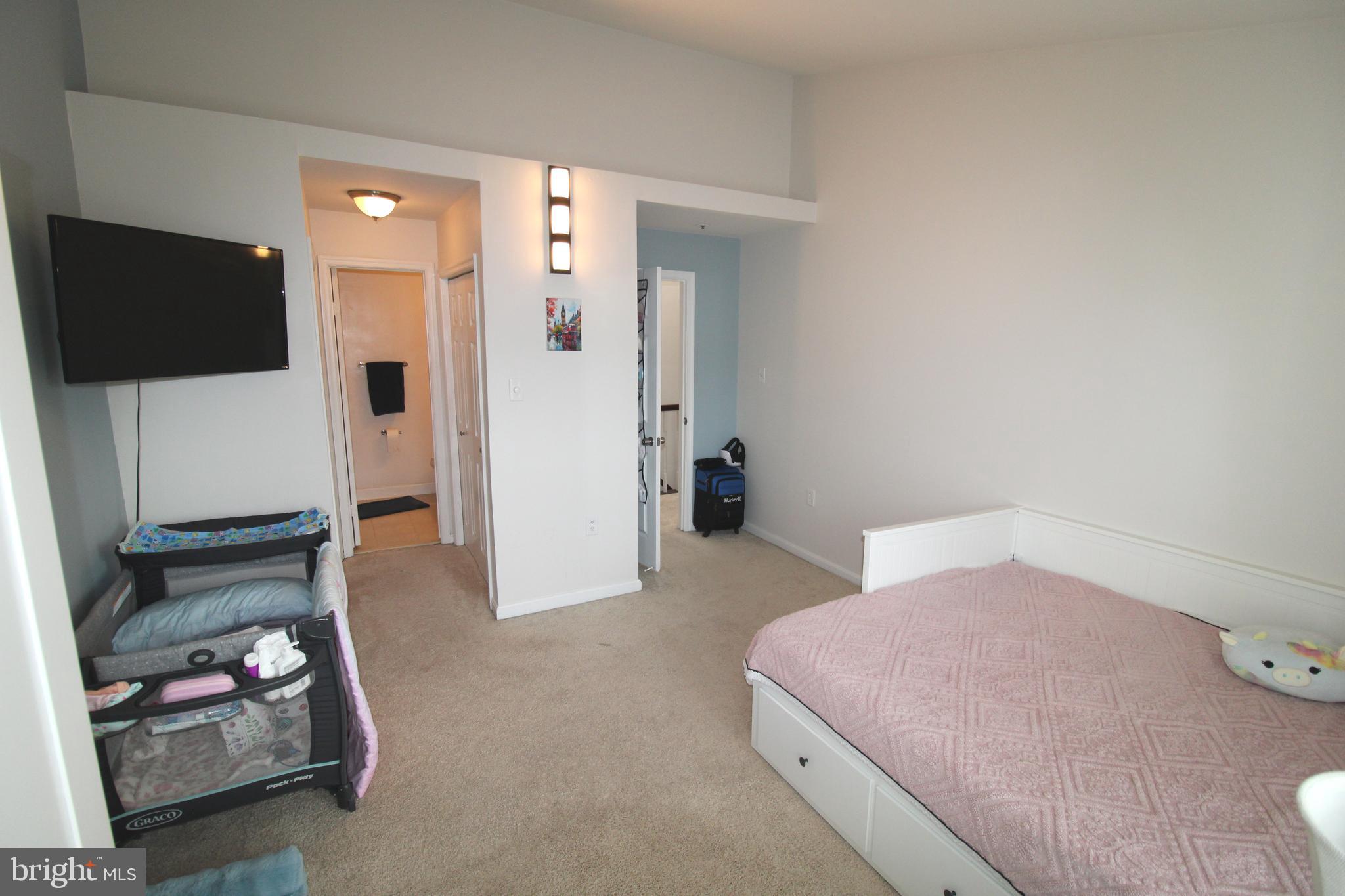 7863 Apache Ridge Court Manassas, VA 20109 - Photo 22 of 38 a bedroom with a bed and a flat screen tv