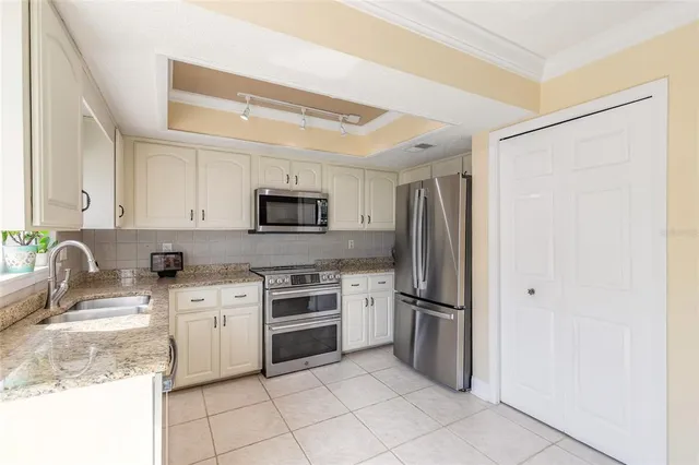 a kitchen with stainless steel appliances granite countertop a refrigerator sink and stove