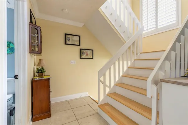 a view of staircase with lots of frames on wall and a window