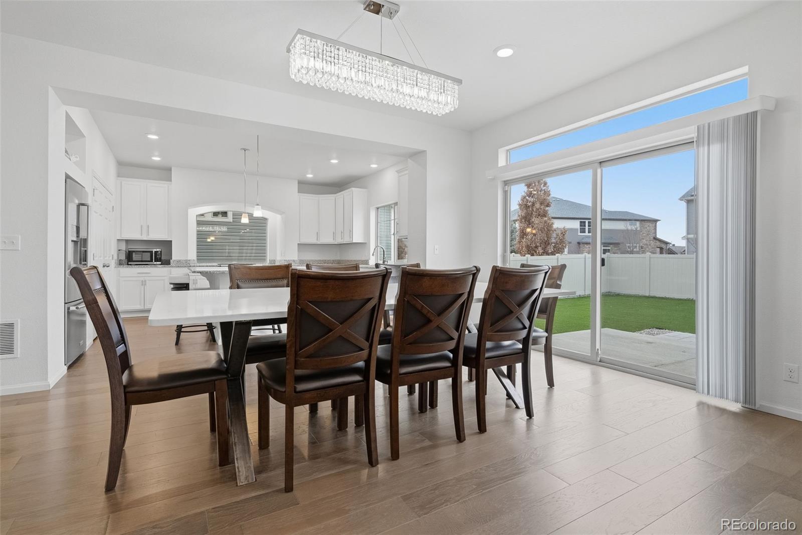 5017 Liverpool Street Denver, CO 80249 - Photo 12 of 42 a view of a dining room with furniture and wooden floor