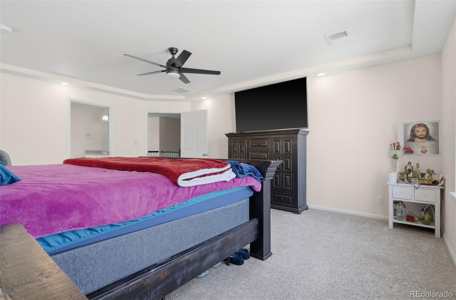 5017 Liverpool Street Denver, CO 80249 - Photo 15 of 42 a bedroom with a bed and a ceiling fan