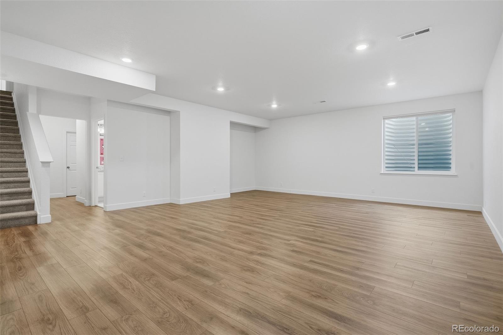 5017 Liverpool Street Denver, CO 80249 - Photo 32 of 42 an empty room with wooden floor and windows