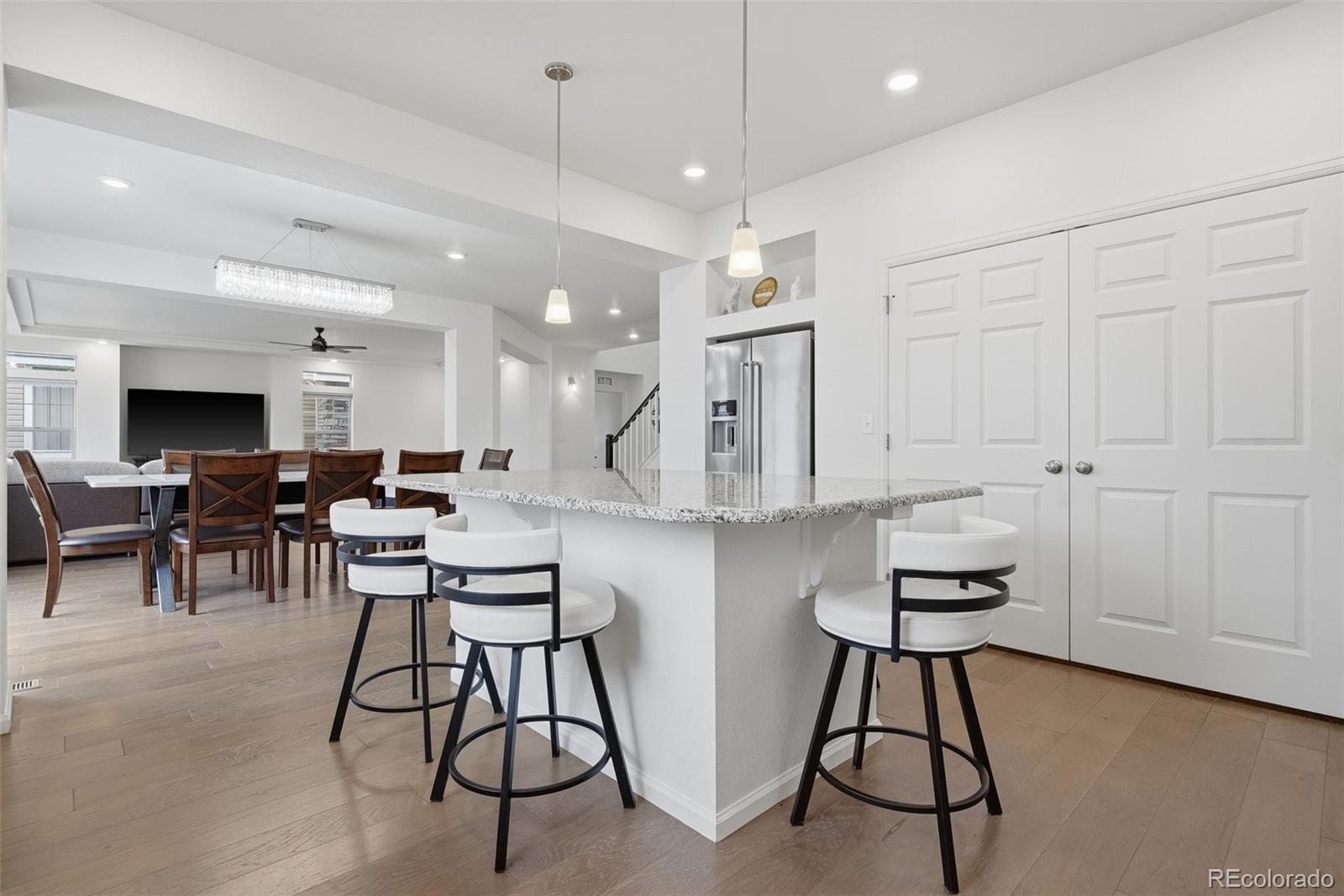 5017 Liverpool Street Denver, CO 80249 - Photo 9 of 42 a open kitchen with stainless steel appliances kitchen island a chandelier