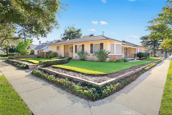 a view of a big house with a big yard and potted plants