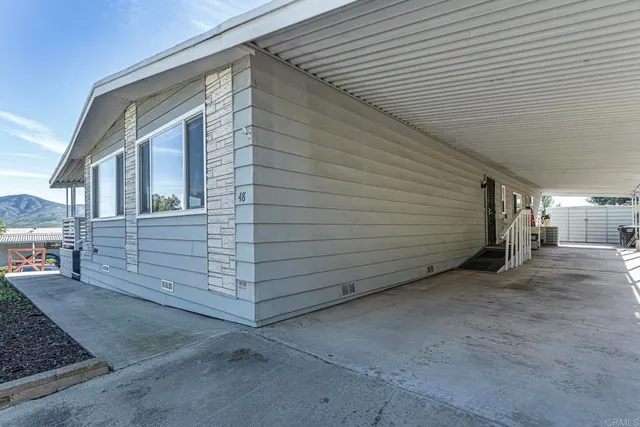 a patio with a table and chairs and plants