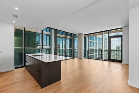 a large living room with a large window and wooden floor