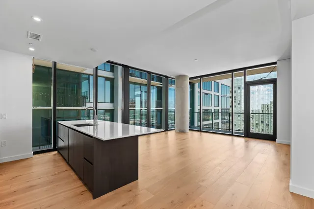 a large living room with a large window and wooden floor