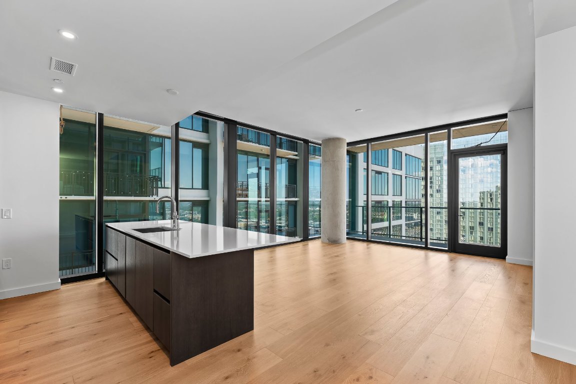 a large living room with a large window and wooden floor