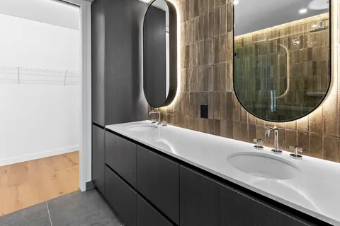 a bathroom with a granite countertop shower a mirror and a sink