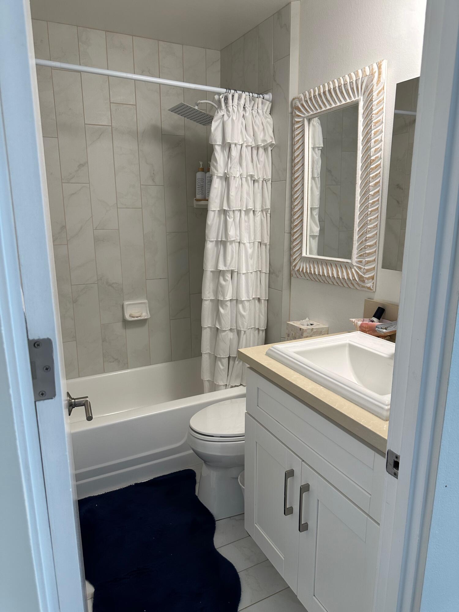 1220 Coast Village Road, Unit 208 Montecito, CA 93108 - Photo 9 of 11 a bathroom with a sink a toilet and a bathtub