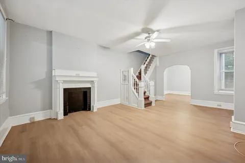 a view of empty room with fan and a fireplace