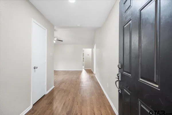 a view of an empty room with a window and a kitchen