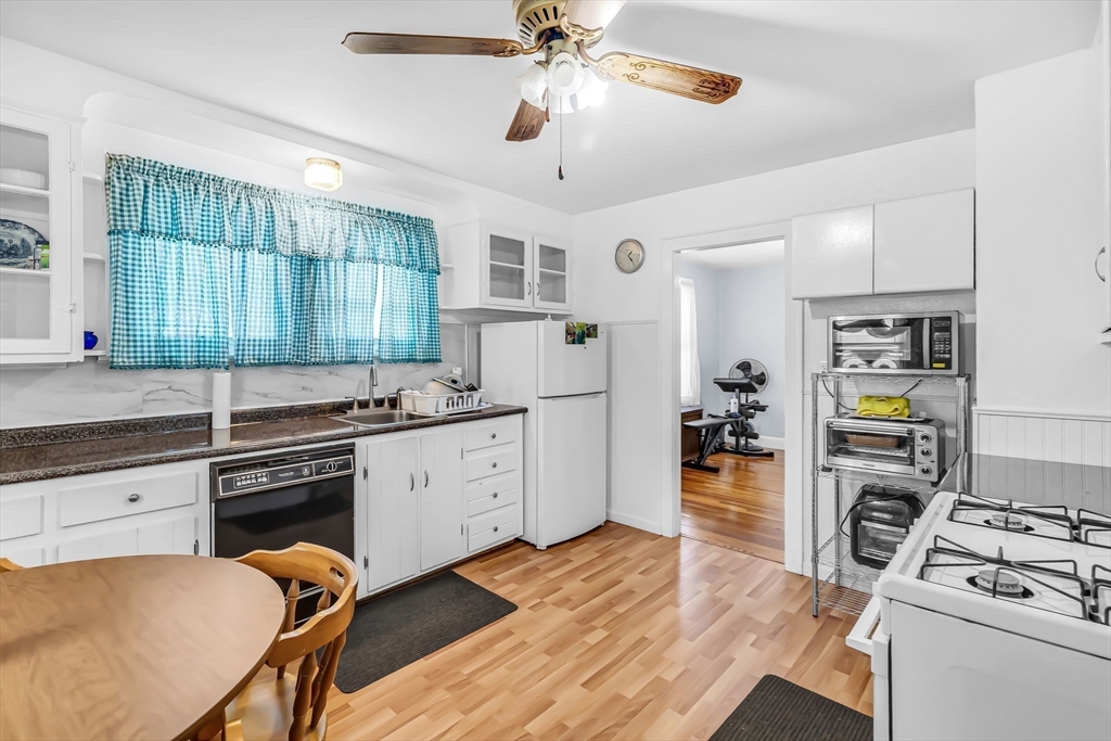 44 Cherrelyn Street Springfield, MA 01104 - Photo 21 of 36 a kitchen with stainless steel appliances granite countertop a stove top oven a refrigerator a sink dishwasher and white cabinets with wooden floor