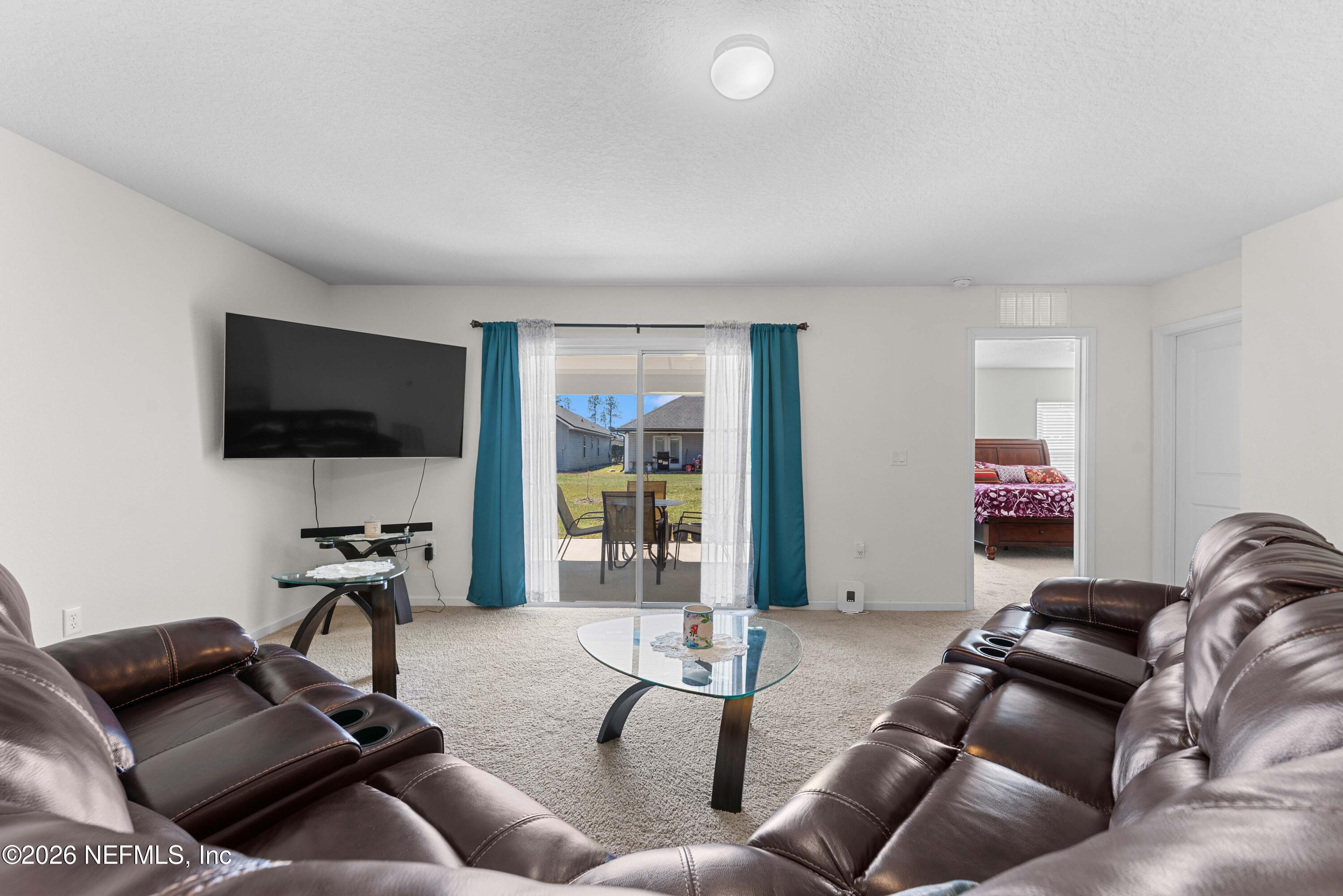 9862 Soldier Court Jacksonville, FL 32221 - Photo 11 of 30 a living room with furniture gym equipment and a flat screen tv