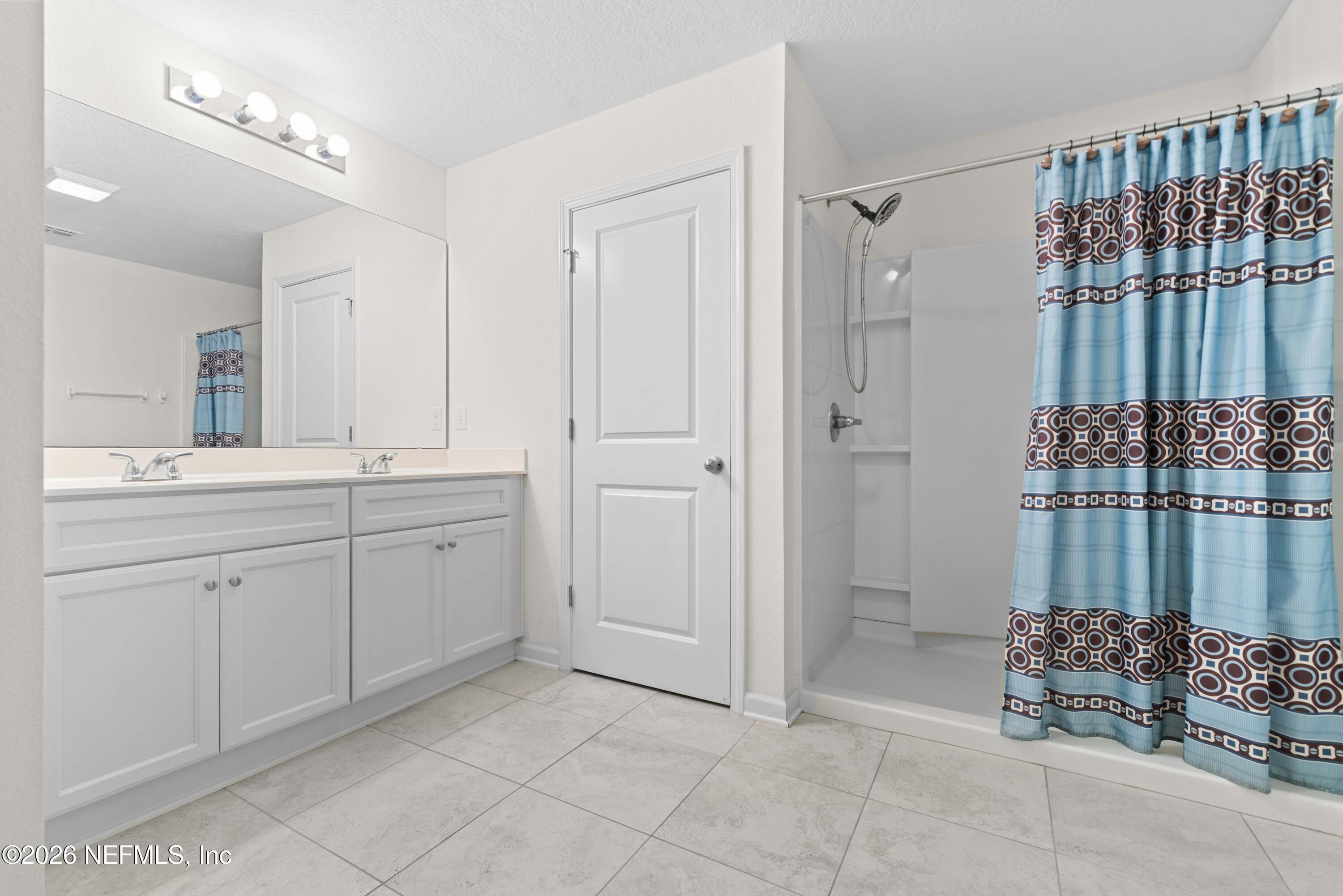 9862 Soldier Court Jacksonville, FL 32221 - Photo 18 of 30 a spacious bathroom with a mirror a shower and vanity