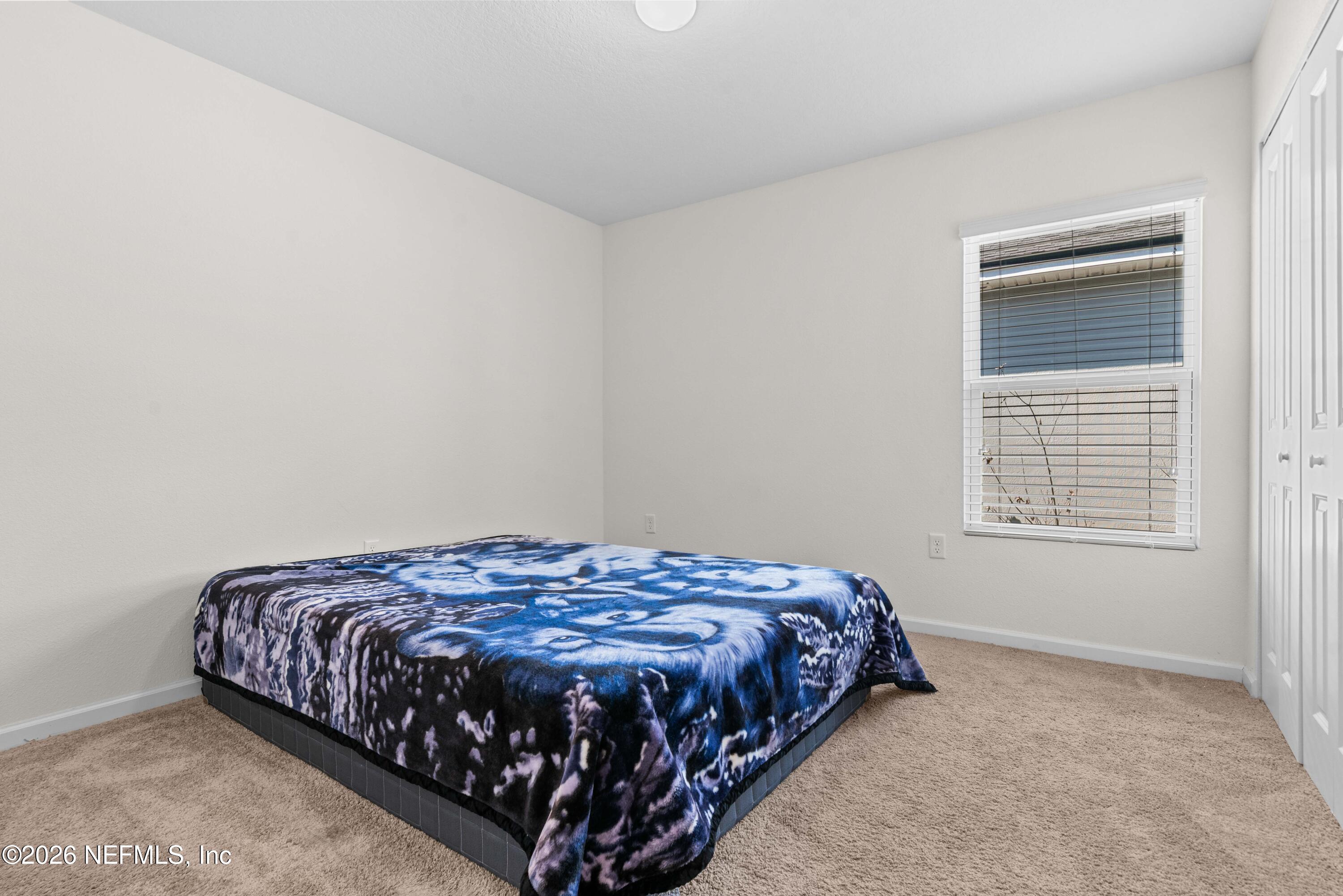9862 Soldier Court Jacksonville, FL 32221 - Photo 22 of 30 a bed sitting in a bedroom next to a window