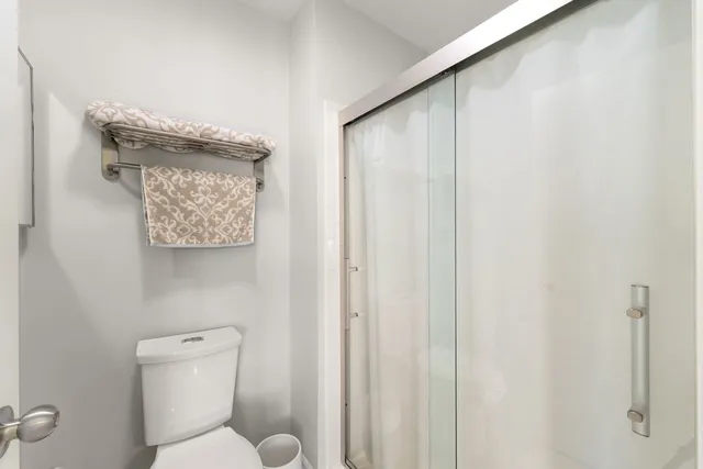 a white toilet sitting next to a shower