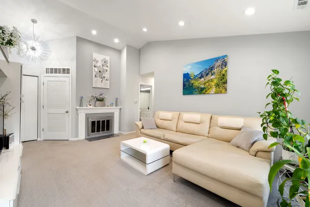a living room with furniture a fireplace and a potted plant