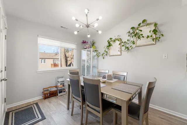 a view of a dining room with furniture a chandelier and wooden floor