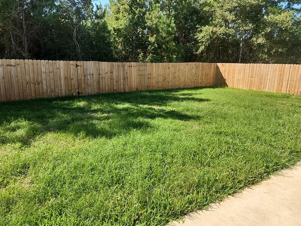 287 Road 5102 Cleveland, TX 77327 - Photo 14 of 16 a view of a backyard with a small cabin and wooden fence