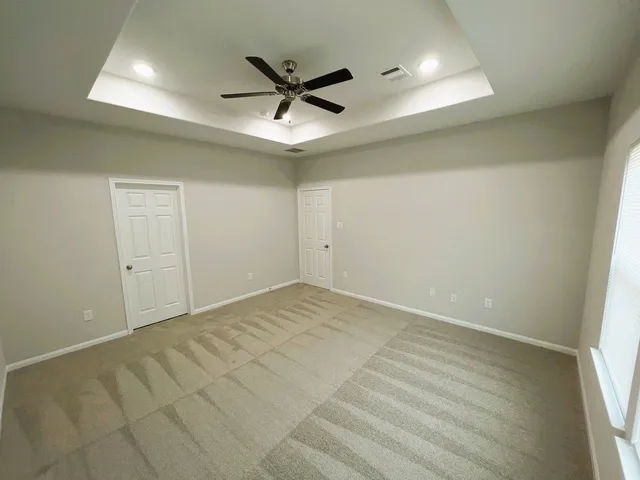 an empty room with a ceiling fan and window