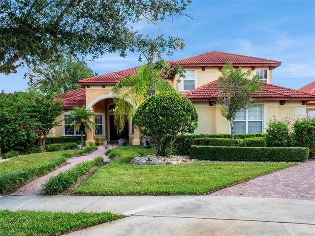 a front view of a house with a yard and potted plants