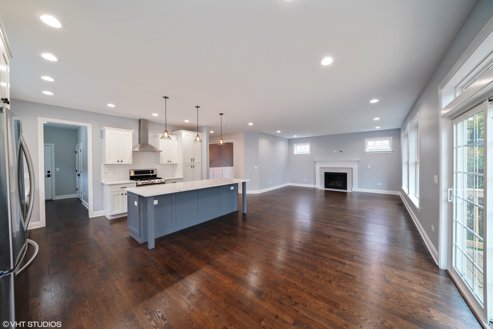 1205 Ridge Road Westmont, IL 60527 - Photo 7 of 16 a large white kitchen with kitchen island a sink wooden floor and a refrigerator