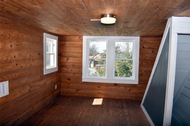 a view of empty room with a window and wooden floor