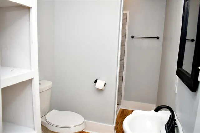 a white toilet sitting next to a bathroom sink and vanity