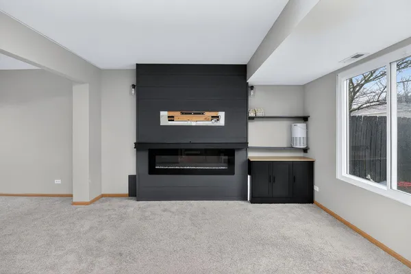 a living room with stainless steel appliances kitchen island granite countertop a refrigerator and a stove