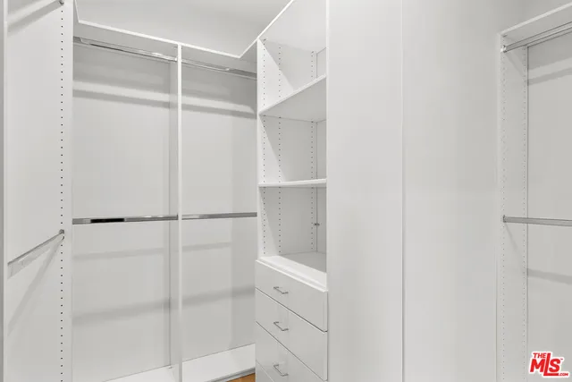 a view of walk in closet with empty racks