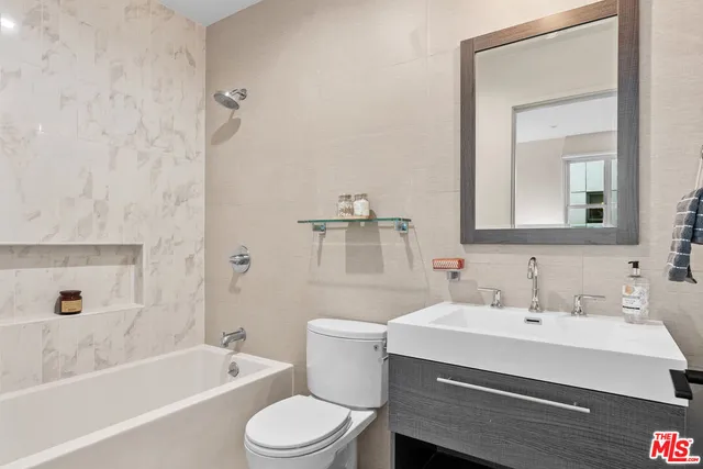 a bathroom with a sink mirror toilet and bathtub