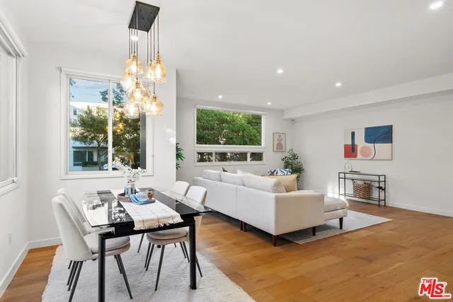 a living room with furniture a flat screen tv and a large window