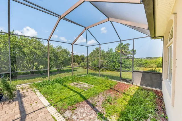 a view of a hallway with wooden floor and a refrigerator