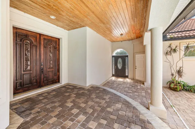a view of an empty room with glass door and windows