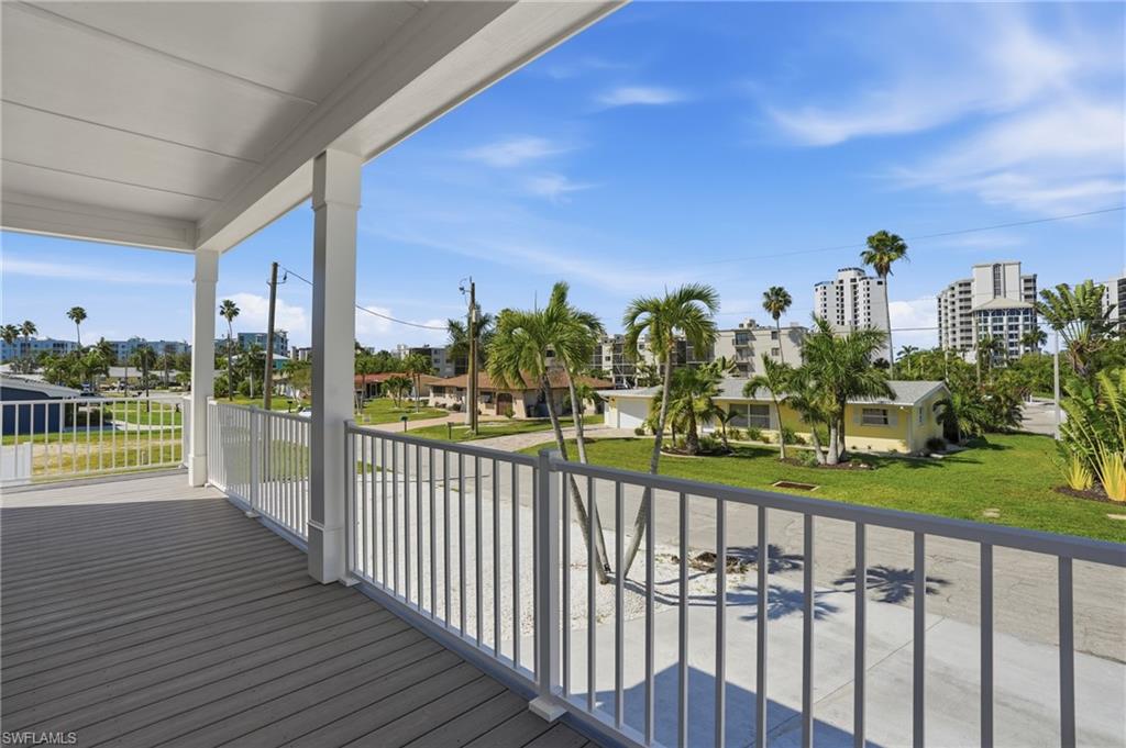 1 Fairview Boulevard Fort Myers Beach, FL 33931 - Photo 23 of 48 Elevated balcony with wood-finish flooring, white railing, and decorative columns - Virtually Edited Image