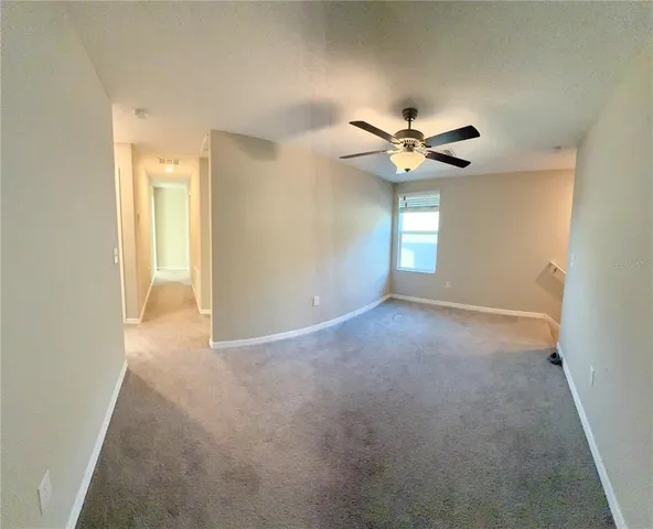 a view of a livingroom with a ceiling fan and window