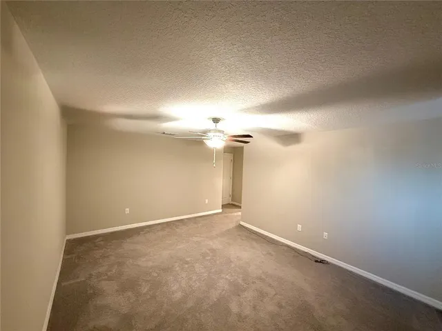 an empty room with a ceiling fan and a window