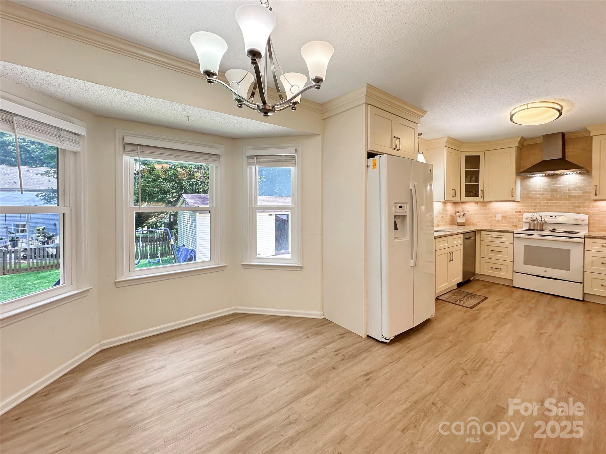 3245 15th Street Northeast Hickory, NC 28601 - Photo 11 of 39 a view of a kitchen with stainless steel appliances granite countertop a stove a refrigerator a sink dishwasher with wooden floor and cabinets