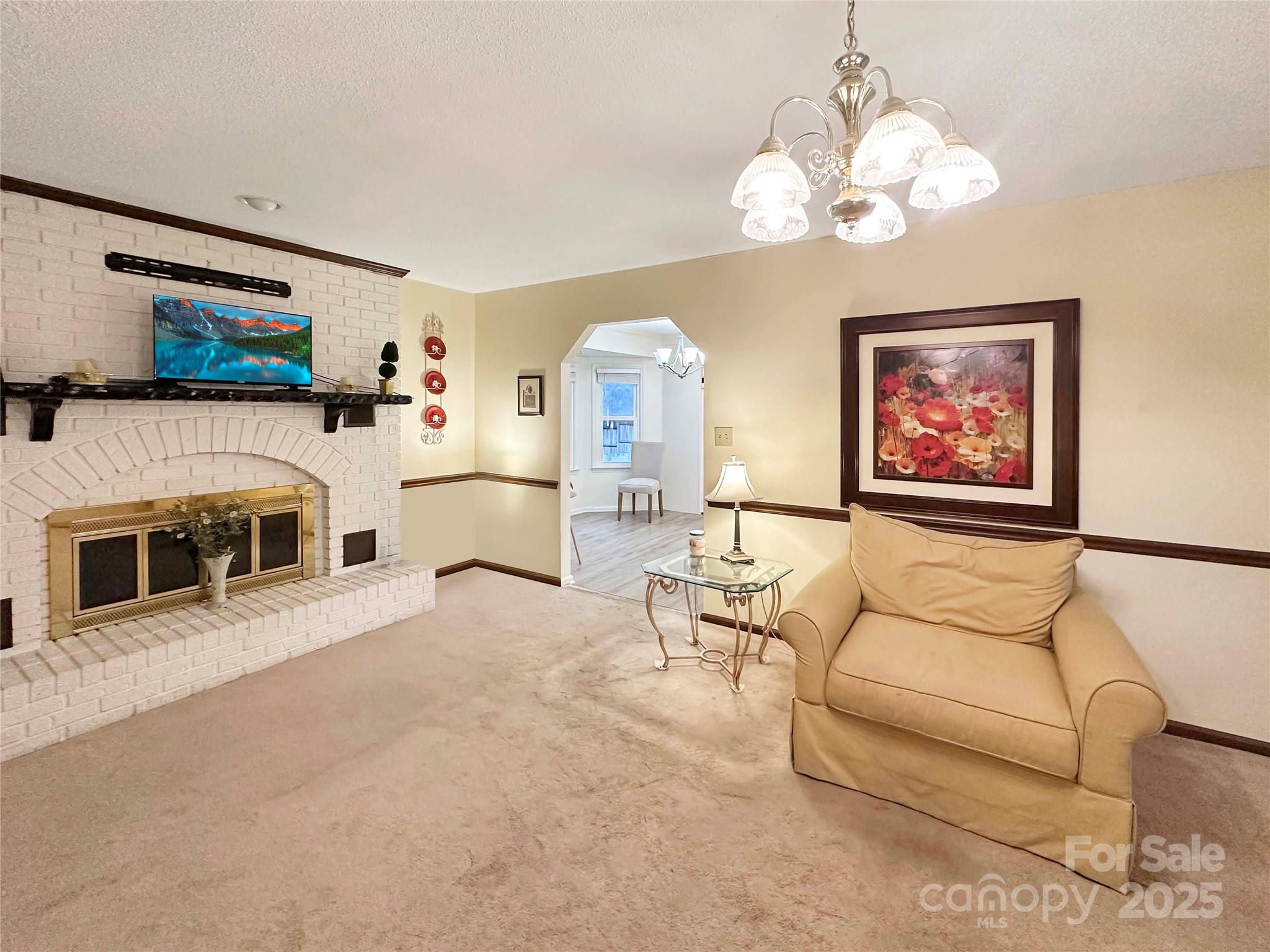 3245 15th Street Northeast Hickory, NC 28601 - Photo 4 of 39 a living room with furniture a fireplace and chandelier