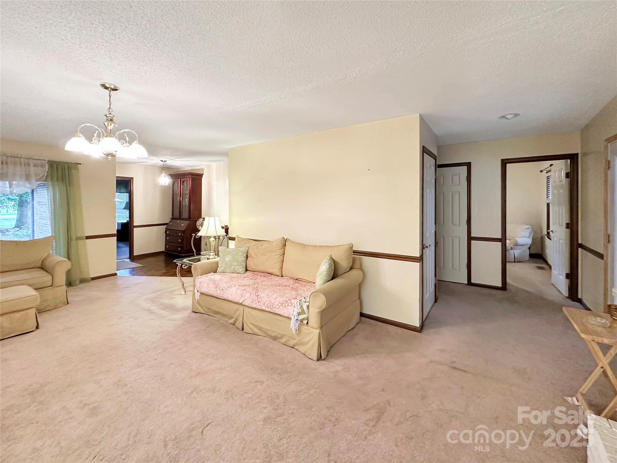 3245 15th Street Northeast Hickory, NC 28601 - Photo 7 of 39 a living room with furniture and a chandelier