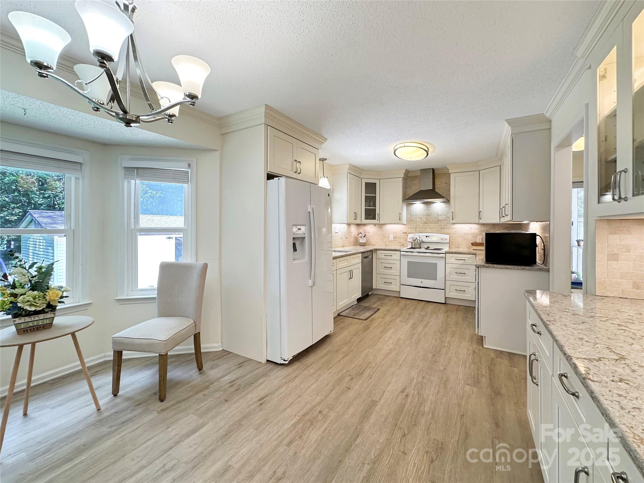 3245 15th Street Northeast Hickory, NC 28601 - Photo 10 of 39 a kitchen with stainless steel appliances granite countertop a refrigerator a stove top oven a sink dishwasher and white cabinets with wooden floor