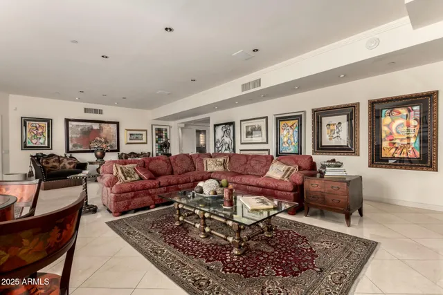 a living room with furniture large windows and wooden floor