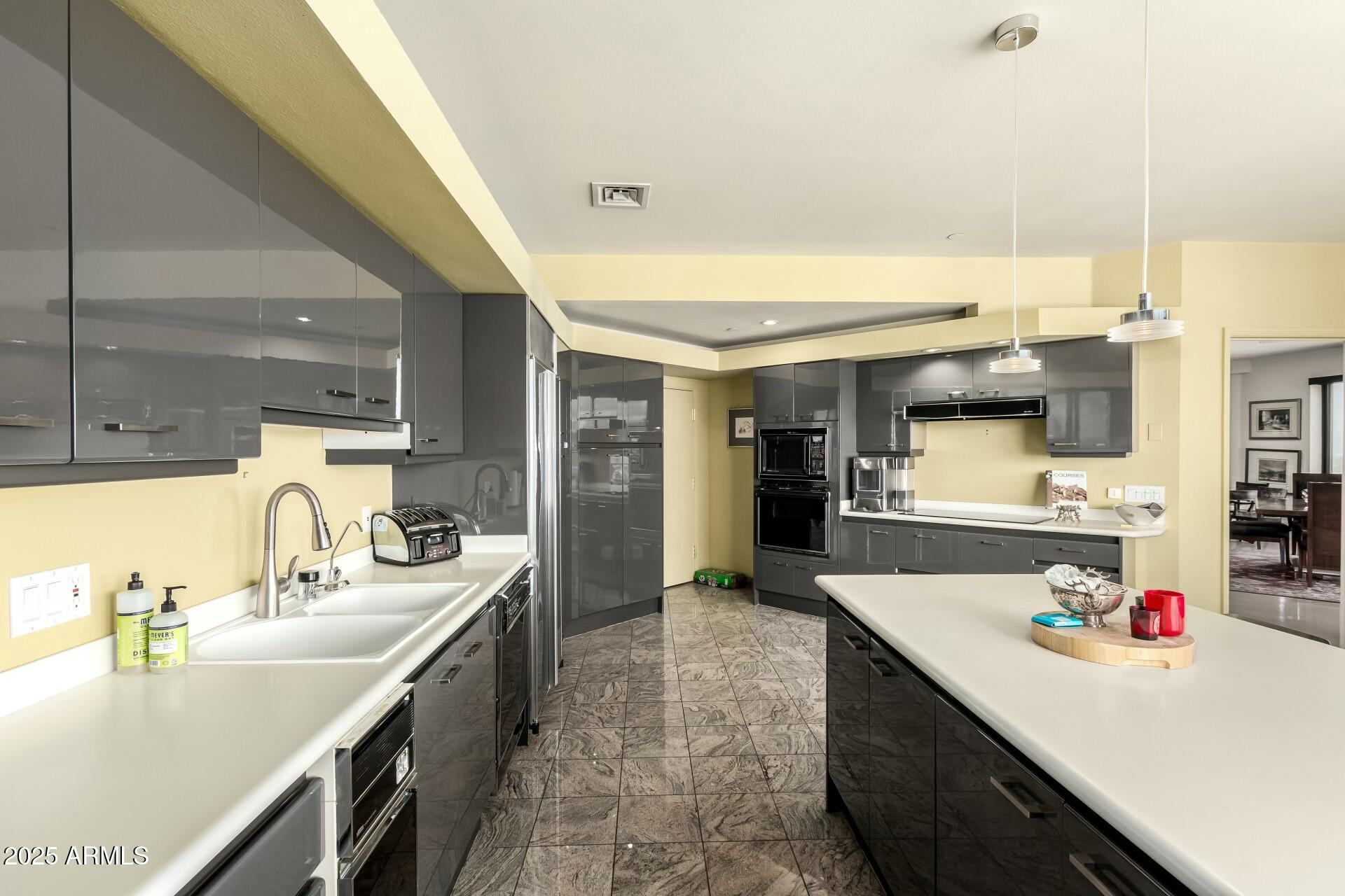 1040 East Osborn Road, Unit 1803 Phoenix, AZ 85014 - Photo 19 of 44 a kitchen with kitchen island a sink stove and refrigerator