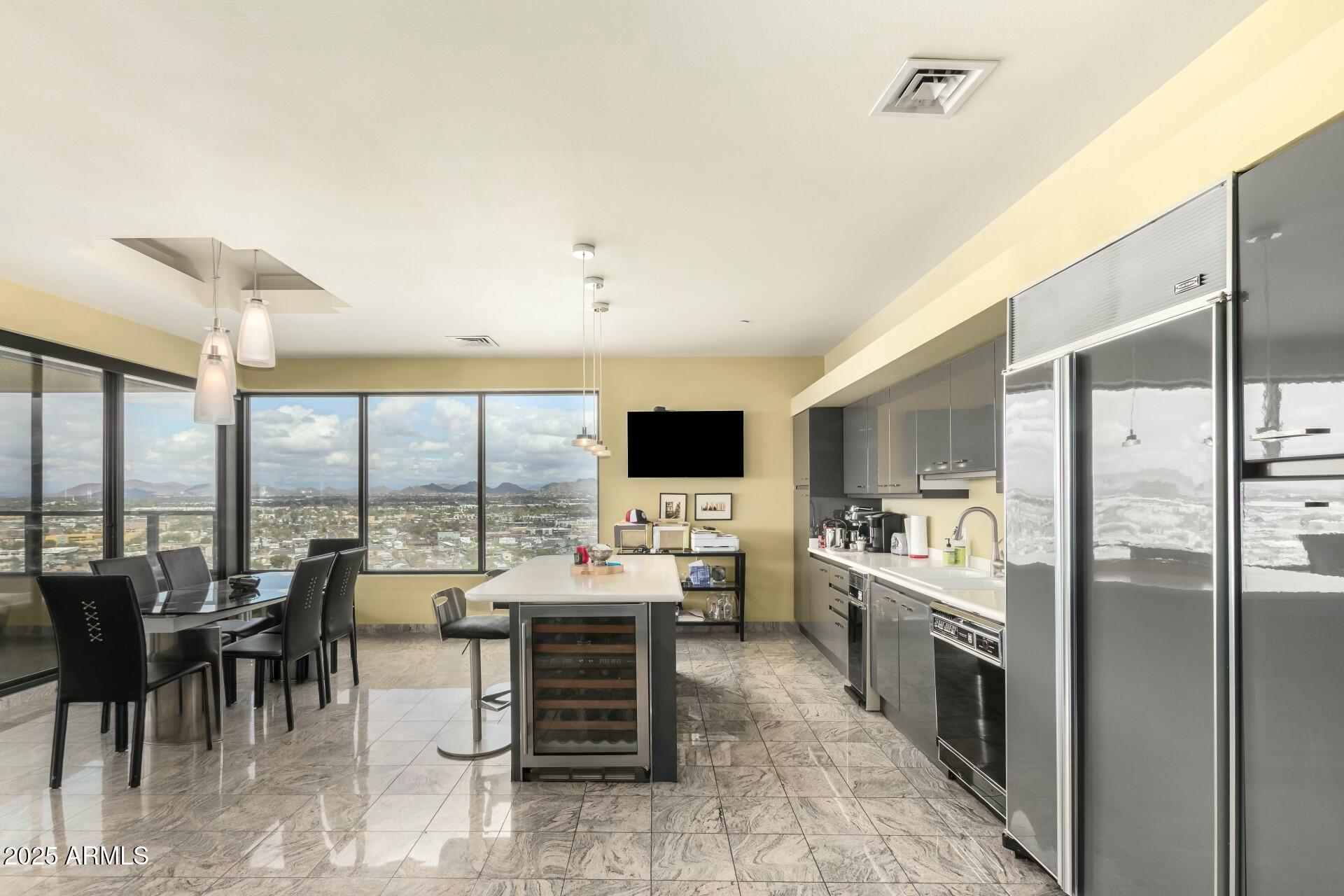 1040 East Osborn Road, Unit 1803 Phoenix, AZ 85014 - Photo 20 of 44 a large kitchen with a large counter top furniture and appliances