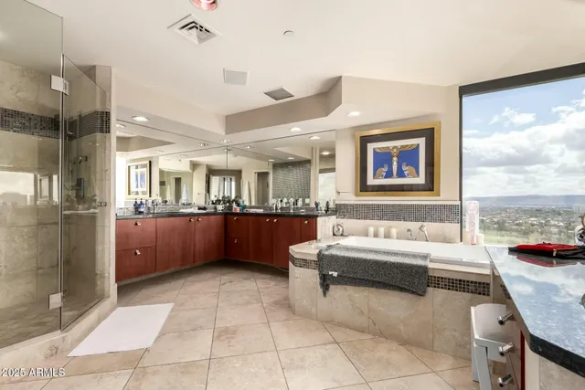 a bathroom with a tub a sink and a large mirror