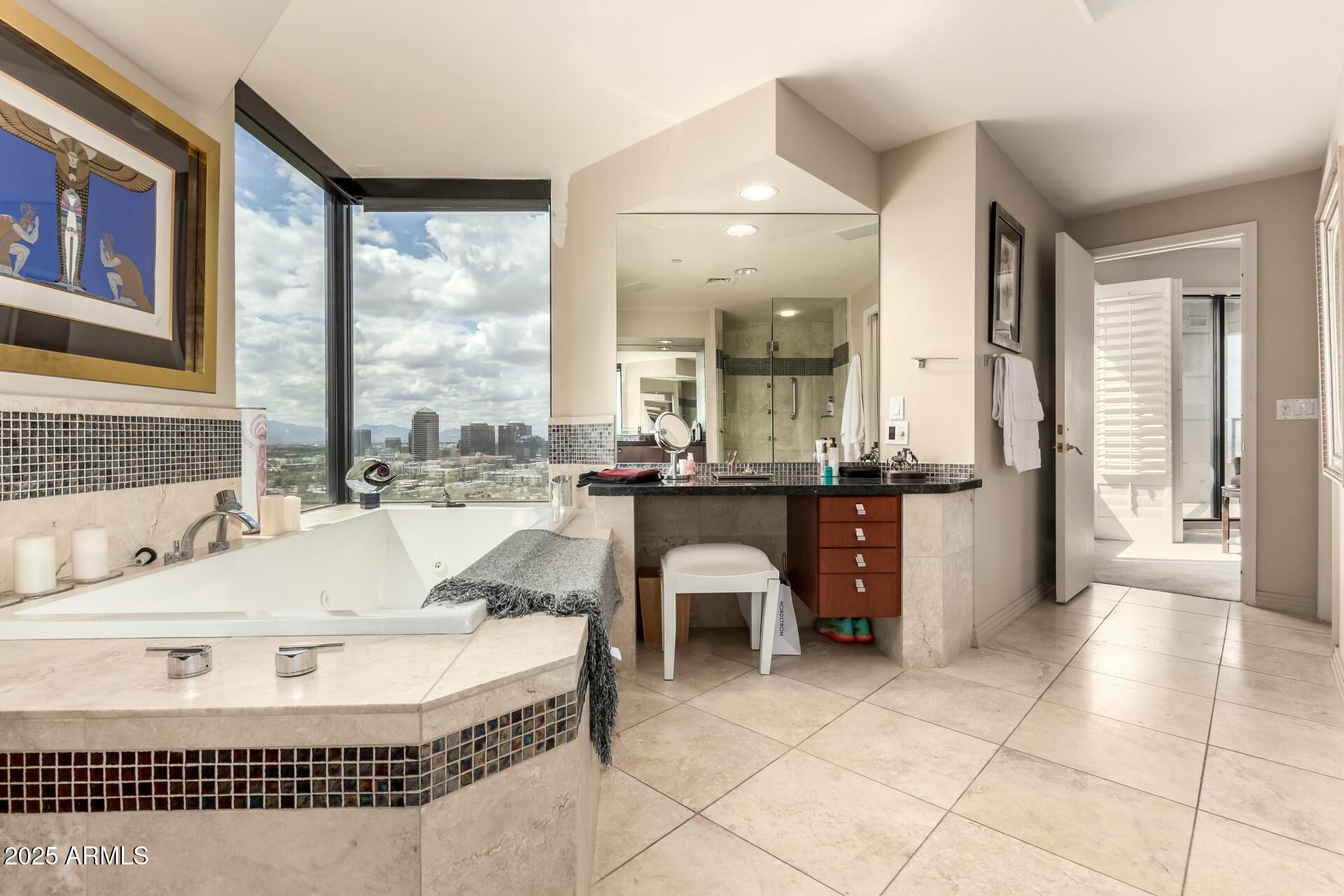 1040 East Osborn Road, Unit 1803 Phoenix, AZ 85014 - Photo 27 of 44 a bathroom with a tub a sink and a large mirror