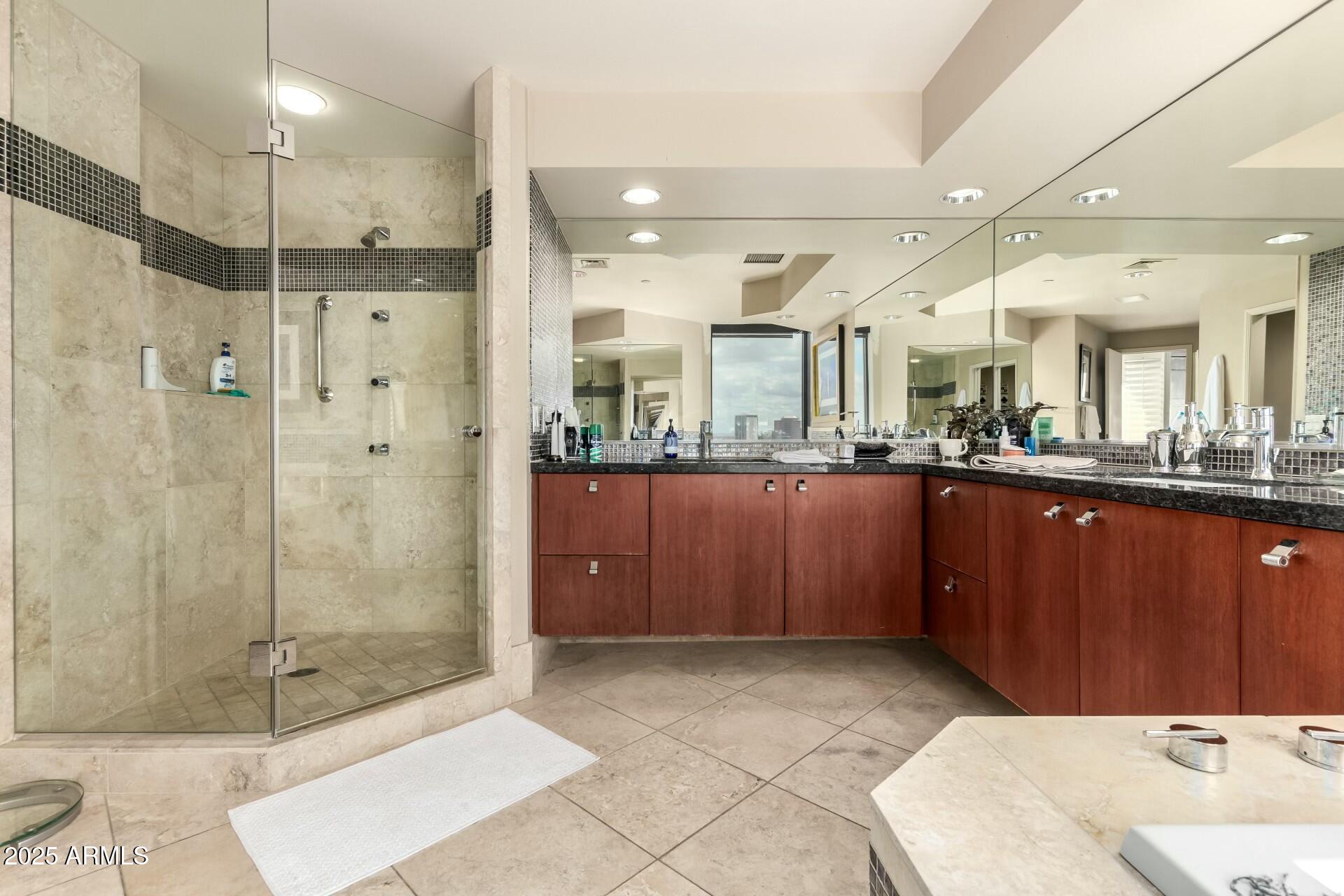 1040 East Osborn Road, Unit 1803 Phoenix, AZ 85014 - Photo 28 of 44 a bathroom with a sink and mirror with shower